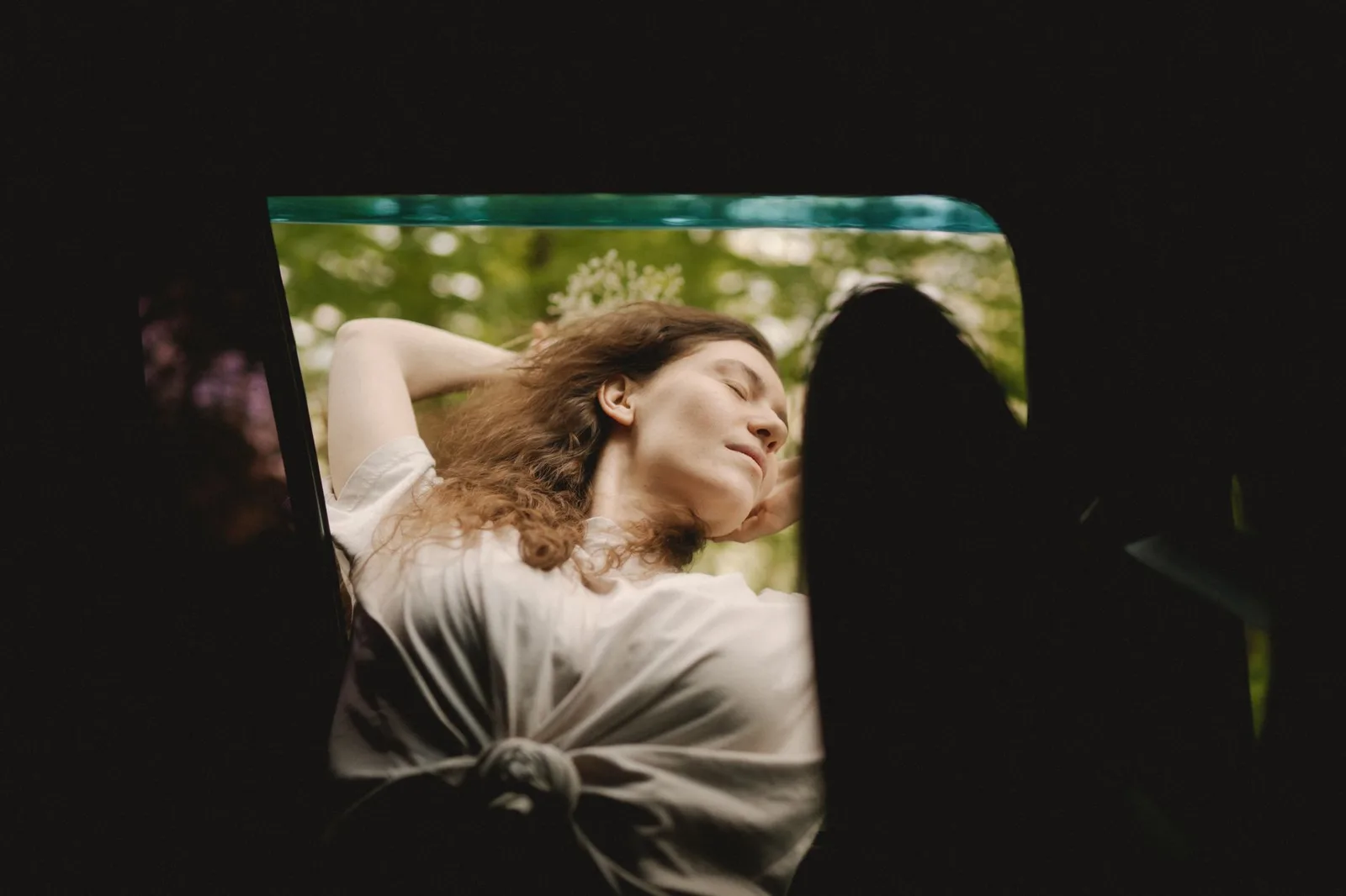 A woman breathing fresh air at an open window