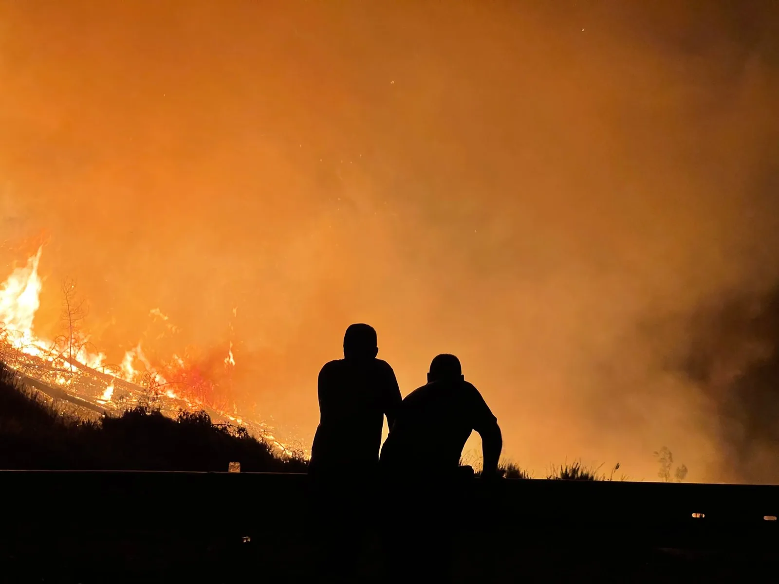 A city under an orange wildfire-smoke sky