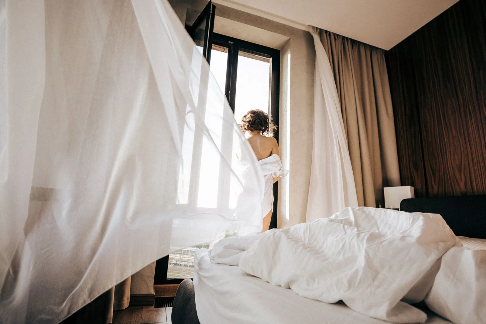 An open window with curtains moving in the breeze